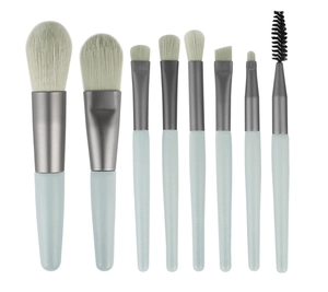 Flat lay of 8-piece mini makeup brush set in light blue with soft bristles on white background
