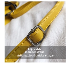 Close-up of yellow faux leather adjustable shoulder strap with silver buckle and stitching