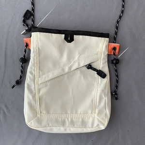 Detail of crossbody canvas bag featuring smooth zippers and adjustable woven strap