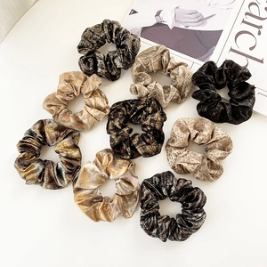 Glossy silk animal print scrunchies in leopard and metallic tones on white background
