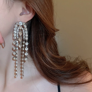 Detail of silver long tassel earrings with sparkling rhinestones in a waterfall design