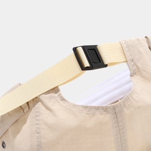 Macro detail of adjustable plastic buckle and ripstop nylon fabric on beige brimless cap
