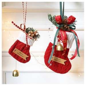 Set of two red cable knit Christmas stockings with pine cones and golden bells
