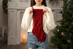 Close-up of red large knitted Christmas stocking with classic cable knit texture pattern