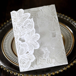 Detailed laser-cut floral wedding invitation card on elegant white pearlescent paper