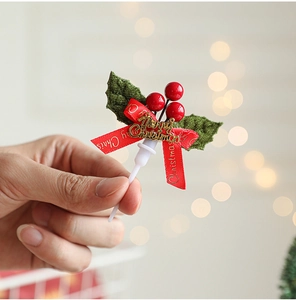 Macro view of a Merry Christmas cake topper with red berries and golden signage