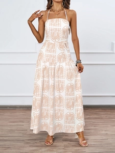 Detail view of the tropical leaf print and layered skirt on the white halter maxi dress
