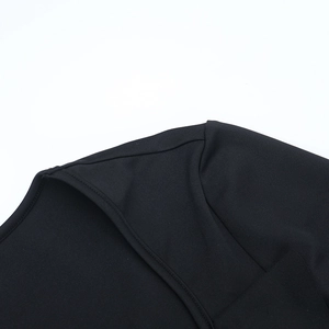 Primer plano del cuello en V con volantes y tejido de punto negro liso del vestido