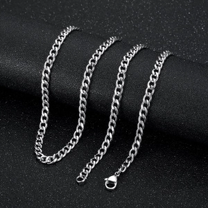 Détail d'un collier à maillons cubains argentés avec fermoir mousqueton sur fond noir