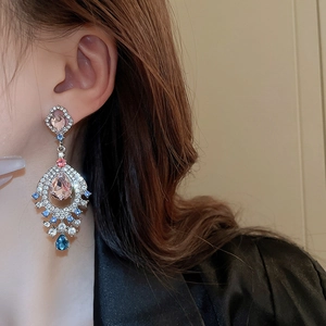 Detail of vintage palace drop earring with pink and blue stones on silver needle