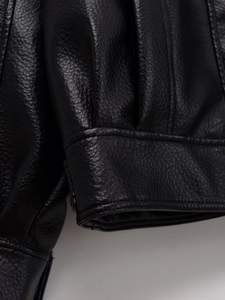 Détail de la veste en cuir PU noir montrant le grain de litchi et les coutures doubles