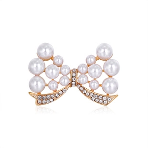 Macro detail of vintage butterfly brooch with white pearls and sparkling crystal rhinestones