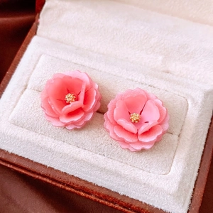 Pink resin flower stud earrings with gold stamen displayed in a velvet jewelry box