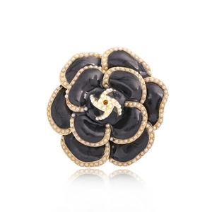 Broche camélia noir élégante avec perles blanches et cadre en métal doré sur fond blanc