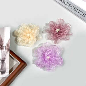 Détail de pinces à cheveux roses en organza faites main en beige, rose et violet