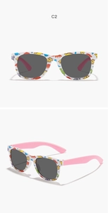 Close-up of kids dinosaur print sunglasses with white frames and pink temples