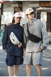 Outdoor street style shot of models wearing off-white and black nylon crossbody waist bags