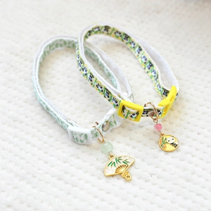 Detail of adjustable pet collars with cute leaf and panda pendants on knit background
