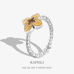 Detail of 925 silver braided ring featuring a textured golden flower relief design