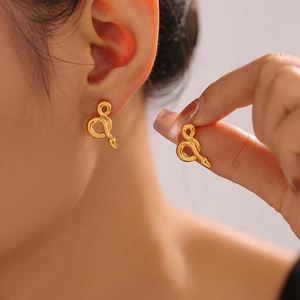 Boucles d'oreilles serpent en acier inoxydable doré 18 carats portées par mannequin