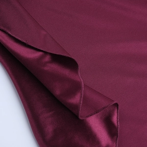 Macro shot of burgundy satin fabric showing twill texture and elegant draping quality