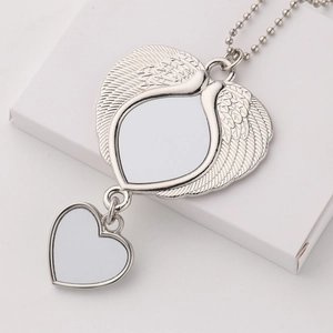Macro shot of silver angel wing pendant with heart charm and blank DIY sublimation insert