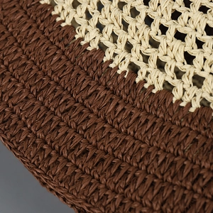 Close-up of dual-tone hand-woven straw bucket hat featuring beige and coffee brown textures