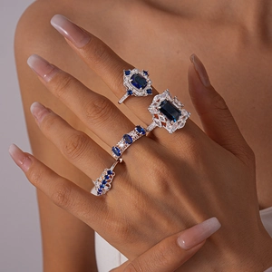 Close-up of vintage silver rings set with blue zircon stones on a model hand