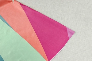 Détail macro de l'imprimé géométrique sur une robe asymétrique aux motifs colorés