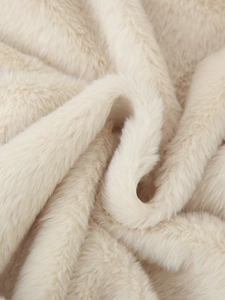 Detail shot of soft faux fur fabric in cream white showing plush texture and fiber quality