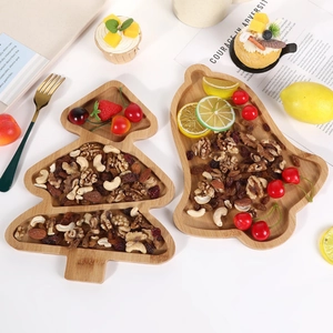 Close-up of Christmas tree and bell-shaped pine wood serving trays with nuts and fruits