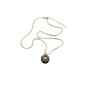 Detail view of a gold-plated evil eye necklace with colorful zircons on a white background