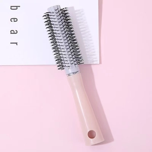 Professional pink and grey vented hairbrush for voluminous styling on a soft pink background
