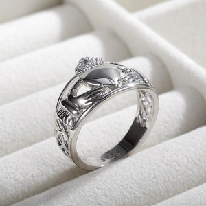 Macro d'une bague Claddagh en argent S925 avec mains tenant un cœur couronné