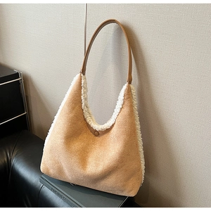 Detail of camel plush tote bag featuring faux shearling trim and brown leather strap