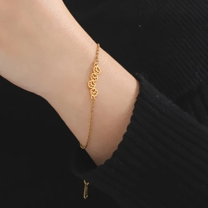 Gold titanium steel bracelet featuring minimalist hollow paw print charms on a link chain