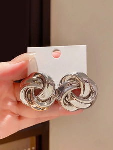 Macro shot of large silver intertwined metal earrings showing S925 post detail