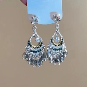 Vista dettagliata di orecchini boho in argento con frange di perline scure e cristalli