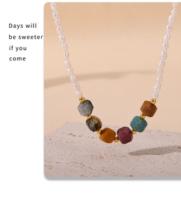 Detail of freshwater pearl necklace with multi-colored gemstones on a stone pedestal