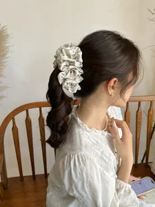 Floral pleated hair scrunchie shown in a ponytail for an elegant hairstyle accessory