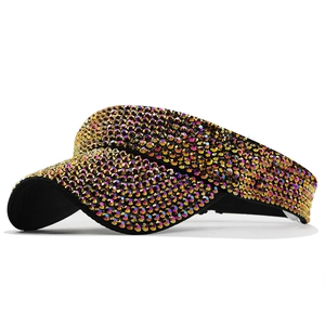 Detail view of luxury sun visor with gold and iridescent rhinestones on black fabric