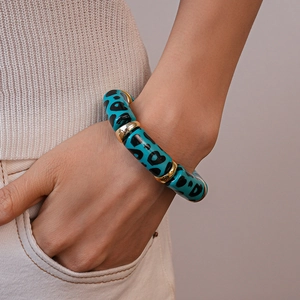 Detail of blue leopard print acrylic beads and gold spacers on a stretch bracelet