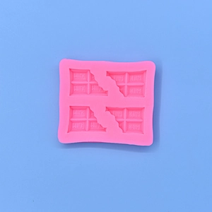 Détail d'un moule en silicone rose à 4 cavités avec texte MILK pour chocolat