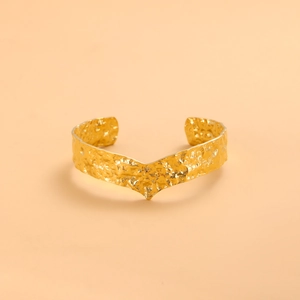 Modern gold open cuff bracelet with irregular hammered texture and unique V-shaped design
