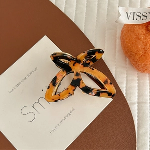 Detailed close-up of a butterfly hair claw clip with brown tortoiseshell pattern