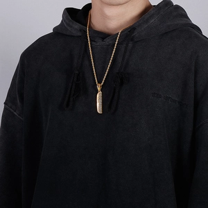 Close-up of a gold-plated titanium steel comb pendant worn by a model in hip hop style