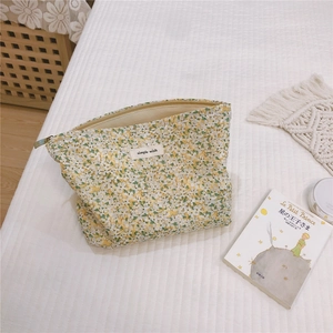 Detailed macro view of cotton floral makeup bag with simple wish label and metal zipper