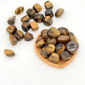 Pietre di occhio di tigre naturali lucide in un vassoio di legno a forma di cuore