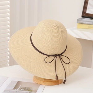 Eleganter beiger Strohhut mit breiter Krempe und braunem Band für den Strand