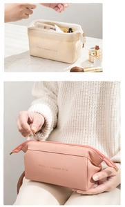 Dettaglio macro delle borse da trucco in pelle PU beige e rosa con scritte dorate